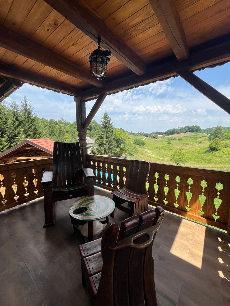 Covered balcony with rustic chairs and a valley view